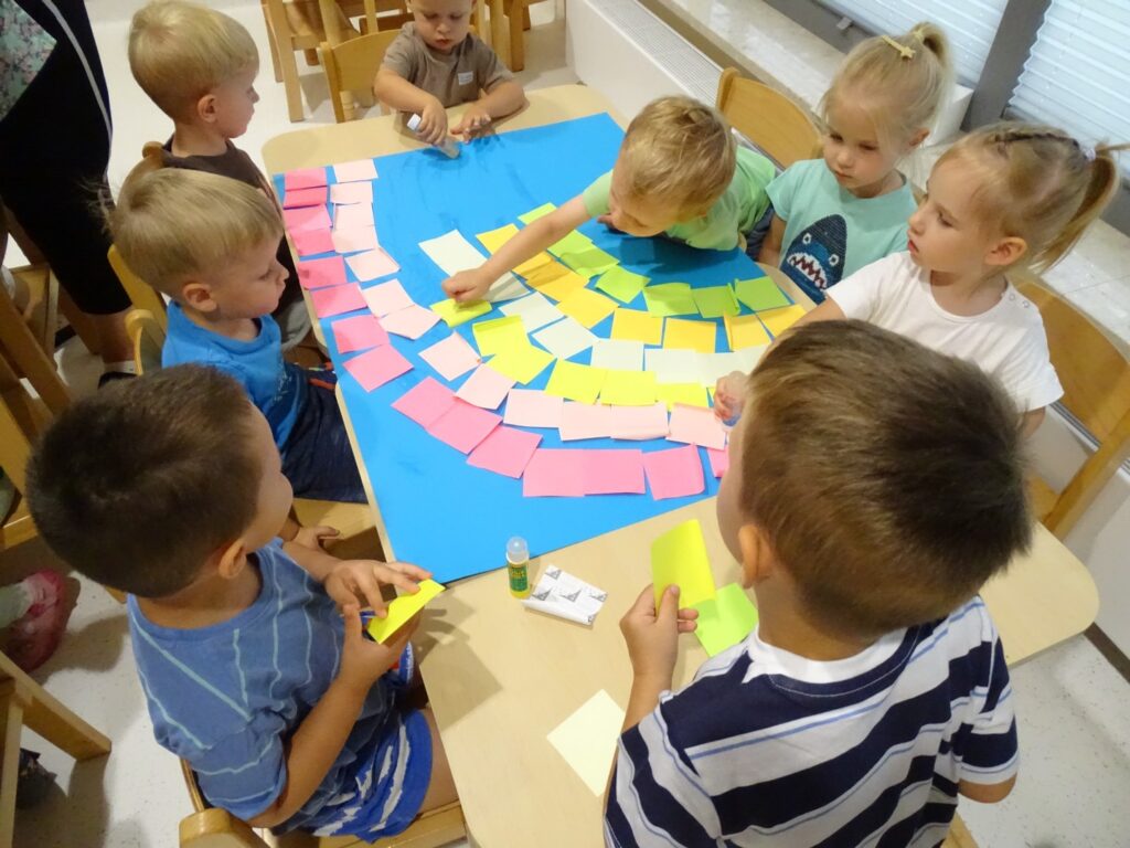 Dzieci wykonują tęczę z karteczek