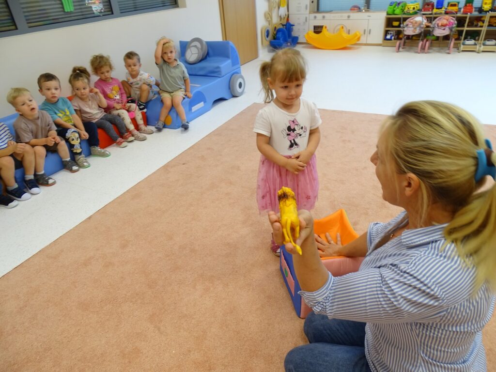 Dziewczynka ogląda figurkę lwa