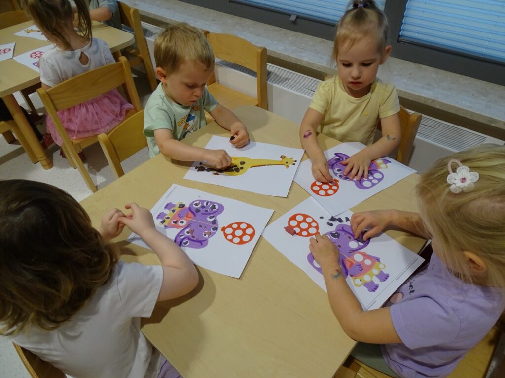 Dzieci wyklejają obrazki plasteliną