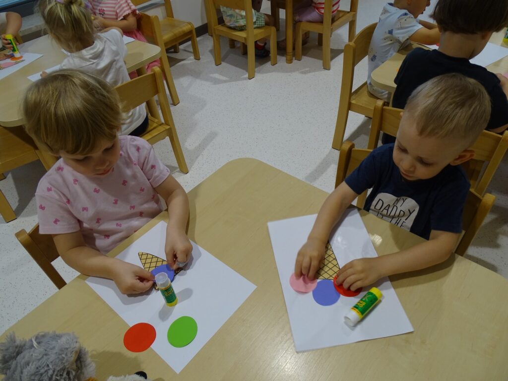 Dzieci naklejają lody z papieru